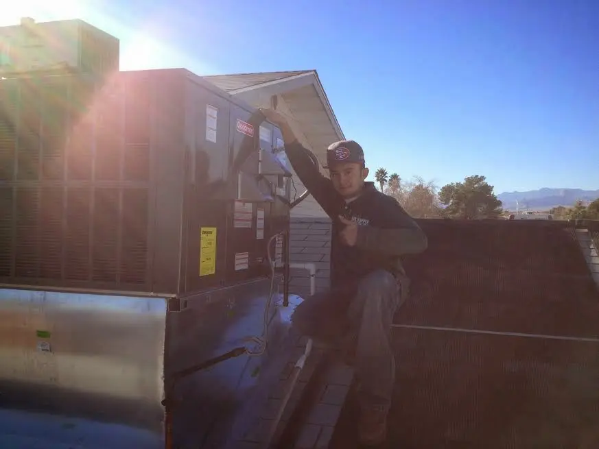 HVAC technician performing Boiler Repair on a rooftop unit in Columbia